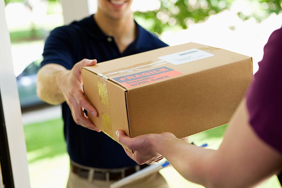 Parcel Delivery Contractor Insurance - Quick Delivery Man Handing a Package to a Homeowner